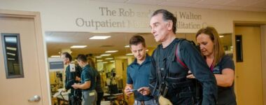 Neurorehabilitation specialists use an exoskeleton to help patients relearn to walk