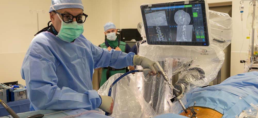 Dr. Juan Uribe performs spine surgery using a robot developed at Barrow