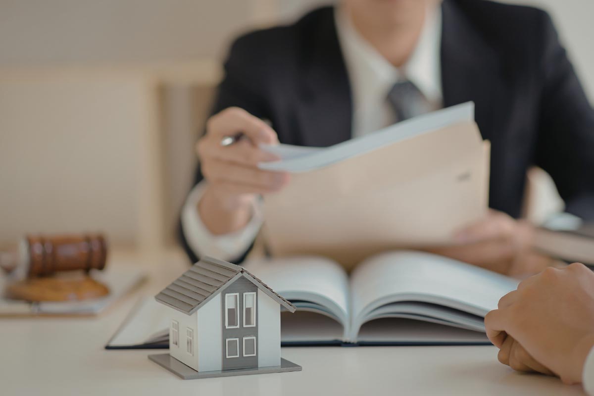 financial planner sitting down at desk with a book with a client